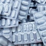 Pastillas de acetaminofén sobre documentos impresos que reflejan riesgo de consumo inadecuado en adolescentes