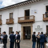 Oficial electoral de Popayán inspeccionando lista del Pacto Histórico en el Cauca y documento constitucional con datos de votación 2022.