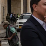 Trabajador empuja carrito frente a edificio oficial en ciudad colombiana