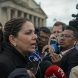 Rueda de prensa con periodistas rodeando a funcionaria en Colombia
