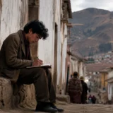 Joven escritor en calle andina del Perú durante comienzos del siglo XX