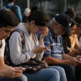 Personas observan contenido en celulares en espacio público urbano