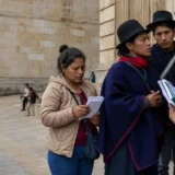 Delegación indígena dialoga con funcionario frente a edificio público