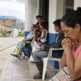 Mujer ora mientras espera atención en un centro de salud colombiano