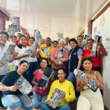 Mujeres participantes del curso de elaboración de bolsos en tela recibiendo materiales y aprendiendo técnicas de costura en el municipio