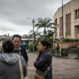 Ciudadanos conversan cerca de una institución custodiada por militares en el Cauca