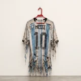 Camiseta número 10 de Messi desgastada sobre una pared blanca