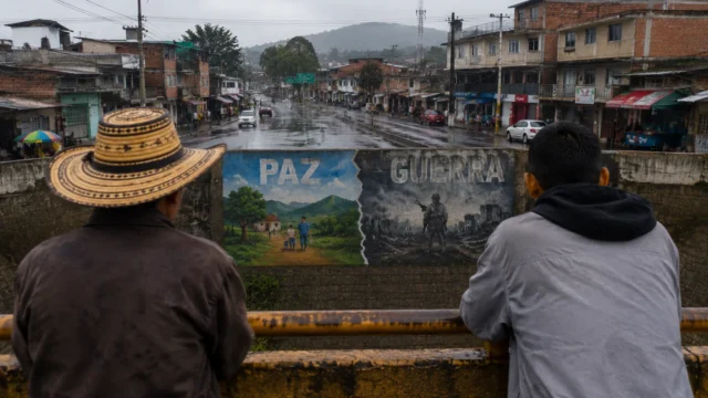 Ciudadanos observan mural sobre paz y guerra en Colombia