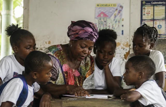 Maestra afrocolombiana acompaña a estudiantes durante una jornada de aprendizaje en el aula