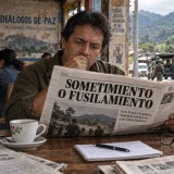 Hombre lee sobre sometimiento y conflicto armado en una cafetería rural de Colombia