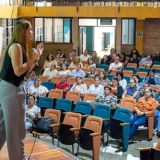 Mujer realiza una exposicion ante un grupo de asistentes en un auditorio del Cauca