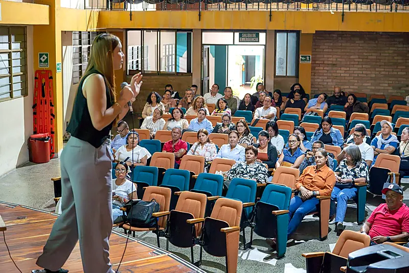 Mujer realiza una exposicion ante un grupo de asistentes en un auditorio del Cauca