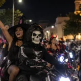 Motociclistas disfrazados de personajes de Halloween participan en una caravana nocturna por las calles de una ciudad colombiana