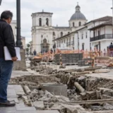 Persona observa una obra pública intervenida en un entorno urbano de arquitectura colonial.