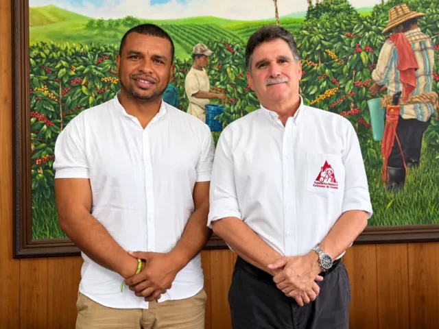 Esneyder Gomez Salamanca y Roberto Castrillon Simmonds frente a una pintura de cafetales del Cauca