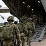 Soldados colombianos con uniformes de camuflaje abordan un avión Hércules de la Fuerza Aeroespacial Colombiana