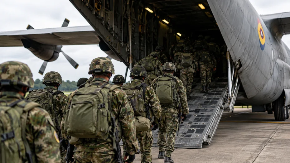 Soldados colombianos con uniformes de camuflaje abordan un avión Hércules de la Fuerza Aeroespacial Colombiana
