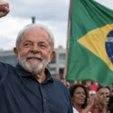 Representacion de Lula con el puño levantado frente a una bandera de Brasil