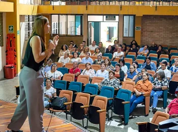 Mujer realiza una exposicion ante un grupo de asistentes en un auditorio del Cauca
