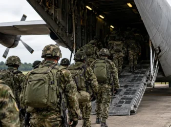 Soldados colombianos con uniformes de camuflaje abordan un avión Hércules de la Fuerza Aeroespacial Colombiana