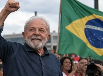 Representacion de Lula con el puño levantado frente a una bandera de Brasil